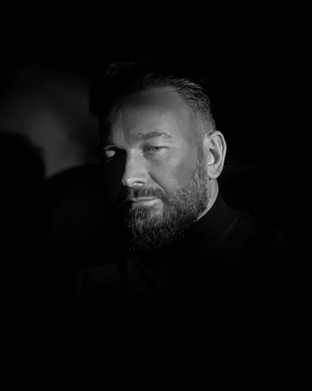 Damian Baran — czarno-biały portret w ciemnym, bocznym świetle