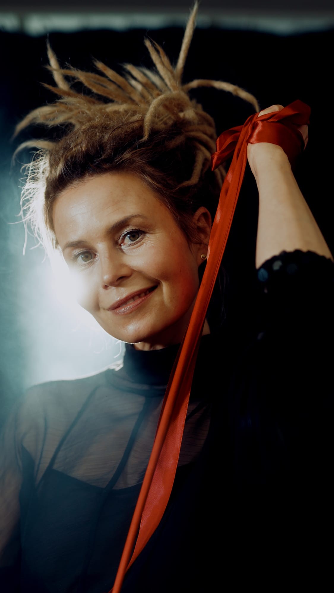 Portret aktorki z uniesioną dłonią i wstążką